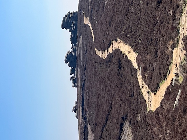 The coach-and-horses rock formation in the distance up a shallow incline