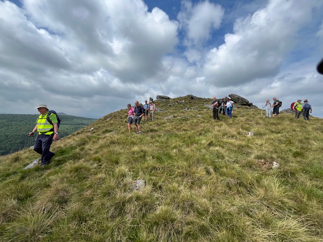 A view looking up a hill with small groups spread out walking down and chatting