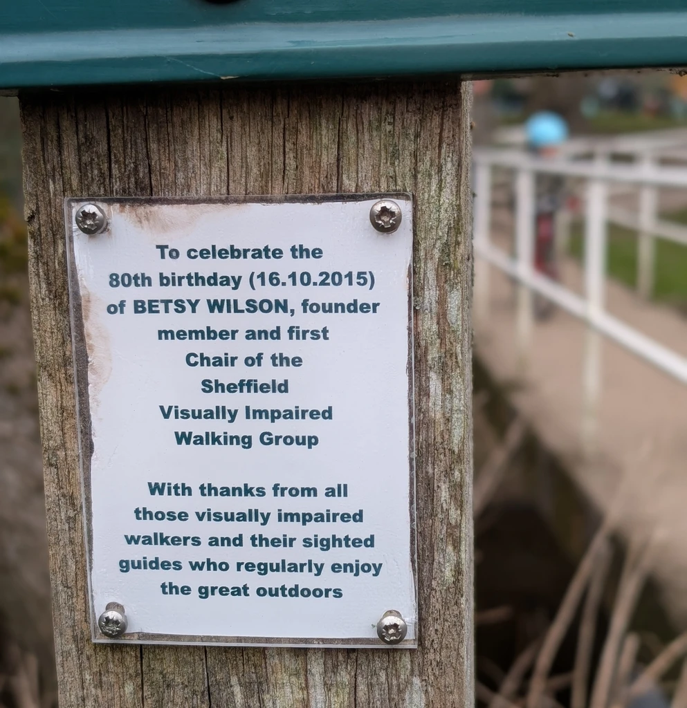 A small 2015 plaque on a post gives thanks to founder Betsy Wilson on her 80th birthday