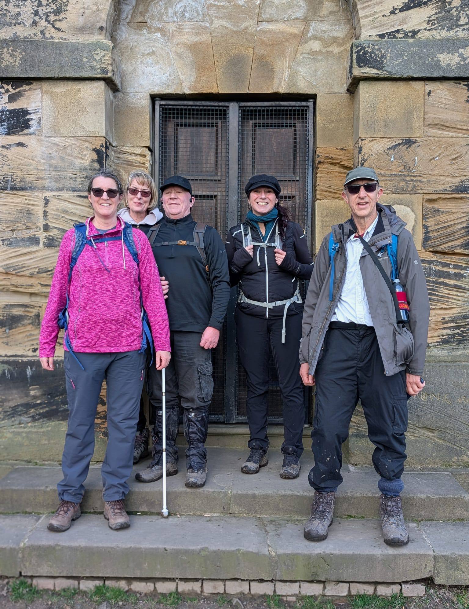 Some of the group smile for a photo on steps leading to a building entrance